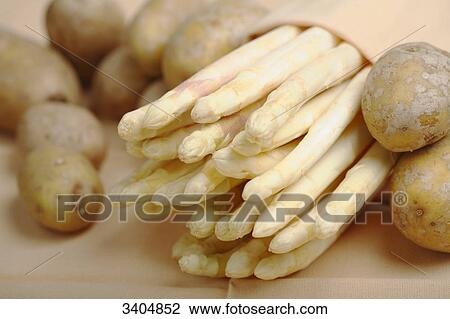 Potatos and a bundle of asparagus, close-up View Large Photo Image Stock Image - Potatos and a bundle of asparagus, close-up . Fotosearch