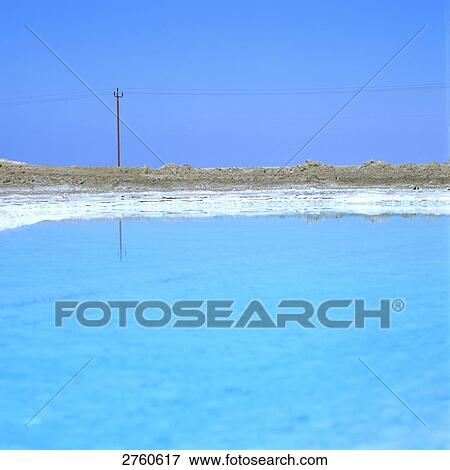 Stock Photo - Reflection of electricity pylon in salt lake, Abu Dhabi, United Arab Emirates . Fotosearch
