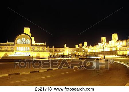 Road running in front of lit up buildings in city View Large Photo Image Stock Photo - Road running in front of lit up buildings in city . Fotosearch