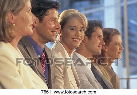 Stock Image - Side profile of five businesspeople sitting in a meeting . Fotosearch