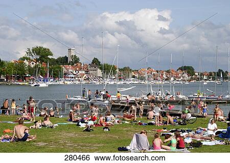 Stock Photograph - Tourists on beach, Mikolajki, Mragowo County, Warmian-Masurian, Poland . Fotosearch