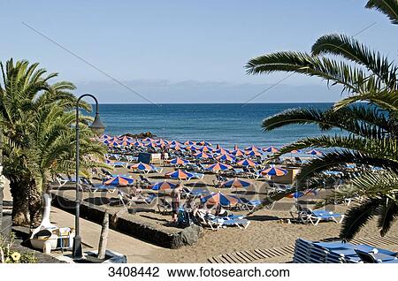 Stock Image - Tourists on the beach, Puerto del Carmen, Lanzarote, Spain, elevated view . Fotosearch