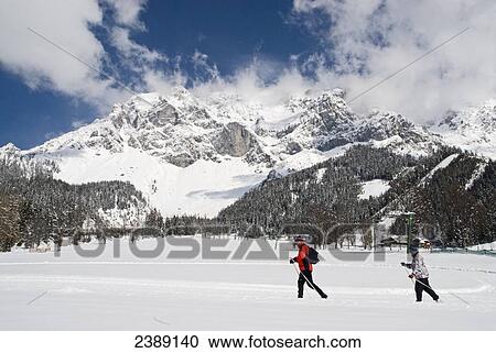 Tourists skiing on snow covered landscape, Dachstein Mountains, Ramsau am Dachstein, Liezen, Styria, Austria View Large Photo Image Stock Image - Tourists skiing on snow covered landscape, Dachstein Mountains, Ramsau am Dachstein, Liezen, Styria, Austria . Fotosearch