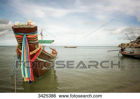 Stock Photograph - Traditional boat at the coast of Ko Phangan, Thailand . Fotosearch