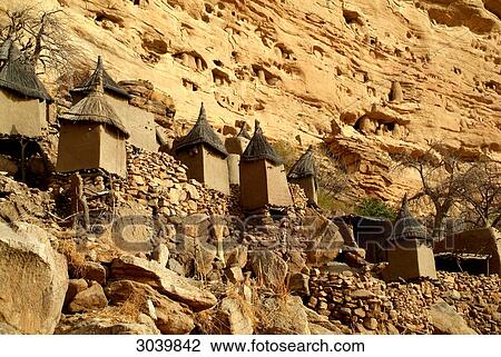Stock Image - Traditional grain silos in front of escarpment at the Dogon village of Songho, Mali . Fotosearch