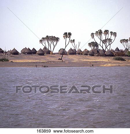 Trees and thatched roof huts in field, Nile River, El Obeid, Kurdufan, Sudan View Large Photo Image Stock Photo - Trees and thatched roof huts in field, Nile River, El Obeid, Kurdufan, Sudan . Fotosearch