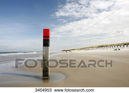 Wooden post on the beach of Texel, beach houses in the background, Netherlands View Large Photo Image Stock Image - Wooden post on the beach of Texel, beach houses in the background, Netherlands . Fotosearch