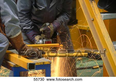 Stock Image - Workers working in metal grinding workshop, Barcelona, Catalonia, Spain . Fotosearch