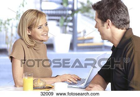 Young couple talking to each other at a breakfast table View Large Photo Image Stock Photo - Young couple talking to each other at a breakfast table . Fotosearch