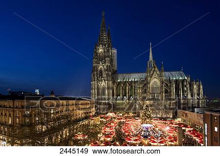Stock Photo - Aerial view of market lit up at dusk in front of cathedral . Fotosearch
