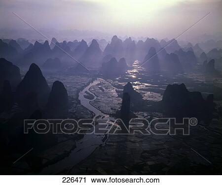 Stock Image - Aerial view of river flowing through landscape, China . Fotosearch
