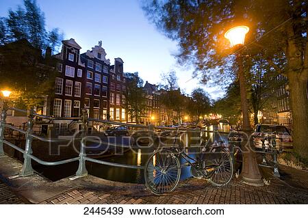Bicycle leaning on railing on bridge over canal, Keizersgracht, Amsterdam, Netherlands View Large Photo Image Stock Photo - Bicycle leaning on railing on bridge over canal, Keizersgracht, Amsterdam, Netherlands . Fotosearch