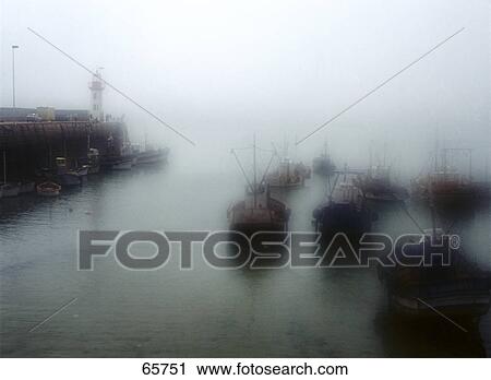 Stock Image - Boat in sea during foggy weather, Brittany, France . Fotosearch
