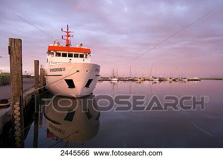 Stock Photograph - Boat moored at dock, Spiekeroog, Lower Saxony, Germany . Fotosearch