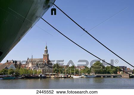 Boat moored at harbor with city hall in background, Leer, Lower Saxony, Germany View Large Photo Image Stock Image - Boat moored at harbor with city hall in background, Leer, Lower Saxony, Germany . Fotosearch