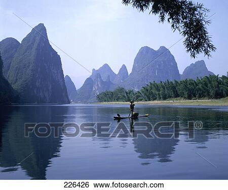 Stock Photograph - Boatman rowing boat in river, China . Fotosearch
