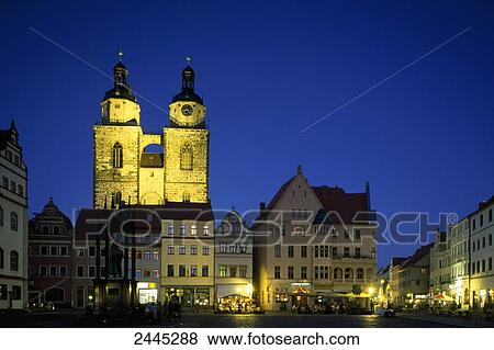 Stock Photo - Buildings in town lit up at dusk . Fotosearch