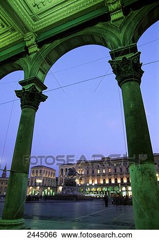 Stock Photograph - Buildings lit up at dusk, Piazza del Duomo, Milan, Lombardy, Italy . Fotosearch