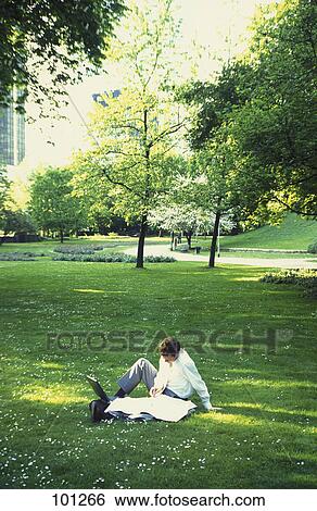 Businessman reading newspaper in park View Large Photo Image Stock Photograph - Businessman reading newspaper in park . Fotosearch