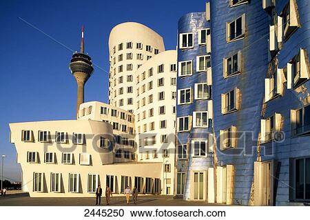 Stock Image - Businesspeople in front of office building, Neuer Zollhof, Media Harbor, Dusseldorf, North Rhine-Westphalia, Germany . Fotosearch