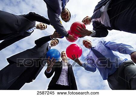 Businesspeople throwing balls, low angle view View Large Photo Image Stock Photography - Businesspeople throwing balls, low angle view . Fotosearch