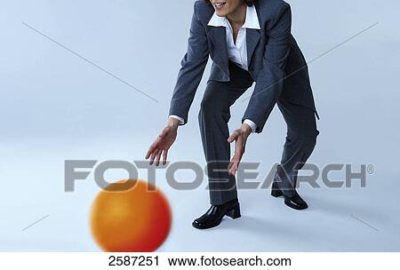 Stock Image - Businesswoman catching ball . Fotosearch