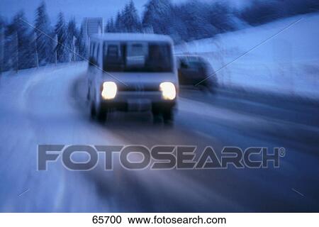Stock Image - Cars on snowy road at dusk . Fotosearch