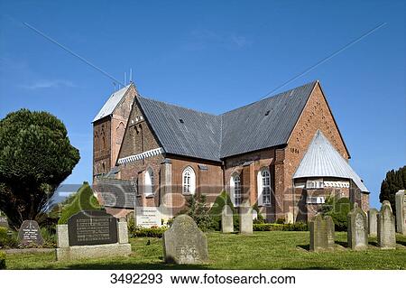 Stock Image - Cemetery in front of the St. Johns Church, Nieblum, Föhr, Schleswig-Holstein, Germany, low angle view . Fotosearch