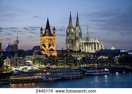 Picture - Church lit up at dusk, Rhine River, Cologne Cathedral, Cologne, North Rhine-Westphalia, Germany . Fotosearch