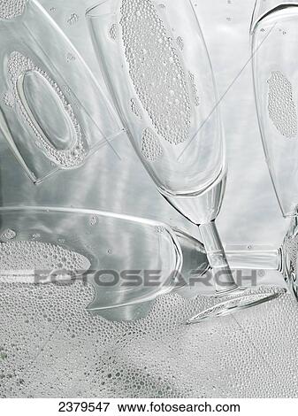 Close-up of champagne flutes with soap sud  View Large Photo Image Stock Photo - Close-up of champagne flutes with soap sud . Fotosearch