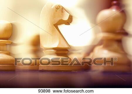 Stock Photo - Close-up of chess pieces on chessboard . Fotosearch
