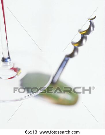 Stock Image - Close-up of corkscrew and stem glass . Fotosearch