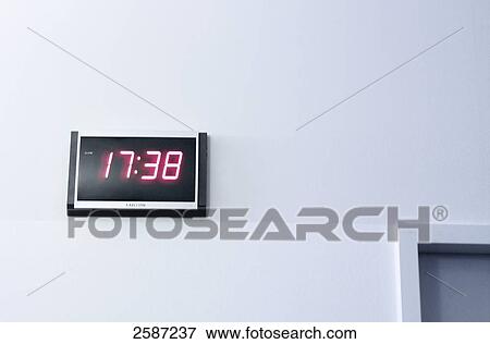 Stock Photo - Close-up of digital clock on wall . Fotosearch