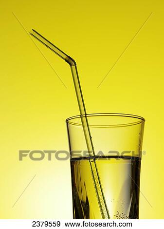Stock Photo - Close-up of glass of drink with drinking straw . Fotosearch