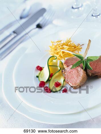 Stock Image - Close-up of lamb chops with zucchini . Fotosearch