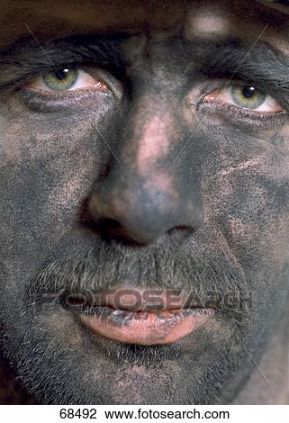 Stock Image - Close-up of male coal miner looking grime . Fotosearch