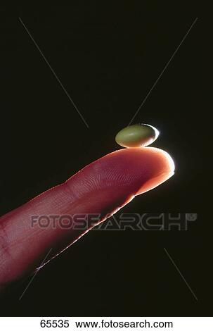 Close-up of pill on person's finger tip View Large Photo Image Stock Photography - Close-up of pill on person's finger tip . Fotosearch