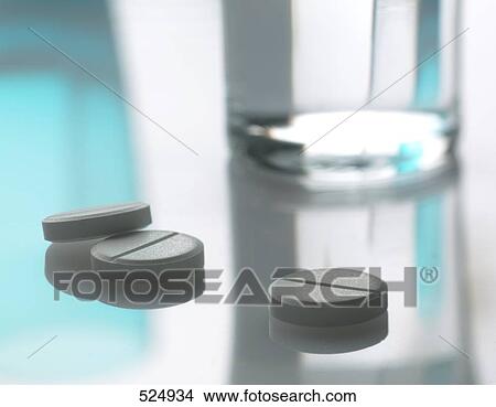 Close-up of pills and glass of water View Large Photo Image Picture - Close-up of pills and glass of water . Fotosearch
