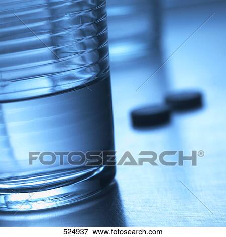 Stock Photo - Close-up of pills and glass of water . Fotosearch
