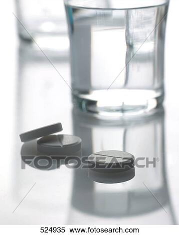 Close-up of pills and glass of water View Large Photo Image Stock Photography - Close-up of pills and glass of water . Fotosearch