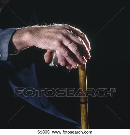 Stock Image - Close-up of senior man holding cane . Fotosearch