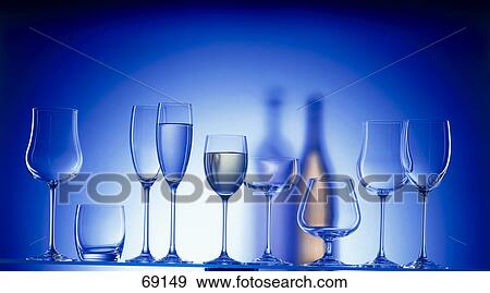 Close-up of stem glasses in row and shadow of bottles in background View Large Photo Image Stock Photo - Close-up of stem glasses in row and shadow of bottles in background . Fotosearch