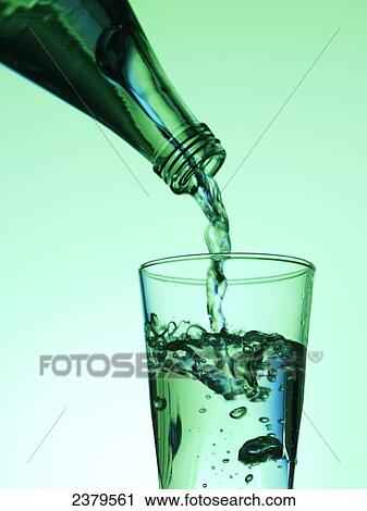 Stock Image - Close-up of water being poured into glass . Fotosearch