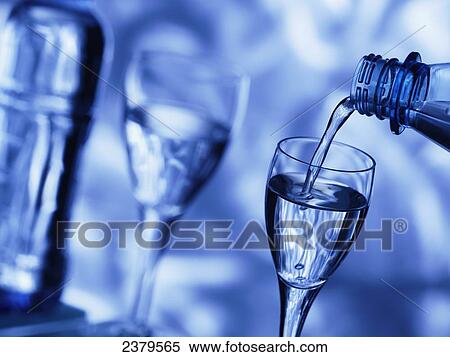Stock Photography - Close-up of water being poured into stem glass . Fotosearch