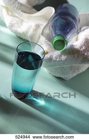 Close-up of water bottle with towel and glass of water View Large Photo Image Picture - Close-up of water bottle with towel and glass of water . Fotosearch