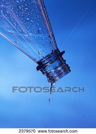 Stock Image - Close-up of water droplets being poured from bottle . Fotosearch