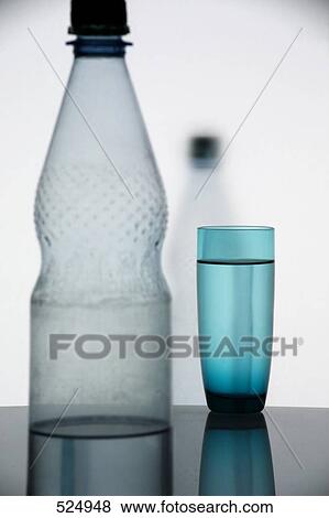 Close-up of water glass and water bottle on table View Large Photo Image Stock Photo - Close-up of water glass and water bottle on table . Fotosearch