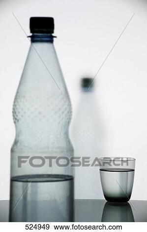 Close-up of water glass and water bottle on table View Large Photo Image Stock Photo - Close-up of water glass and water bottle on table . Fotosearch