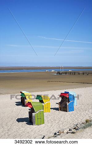 Stock Image - Colourful beach chairs at the beach of Utersum, Schleswig-Holstein, Germany . Fotosearch