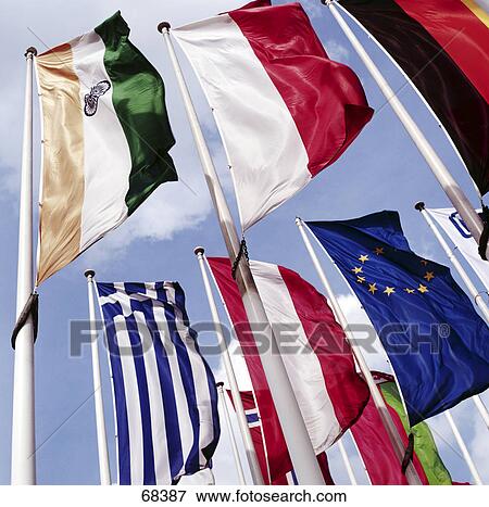 Different national flags fluttering against sky View Large Photo Image Stock Photo - Different national flags fluttering against sky . Fotosearch